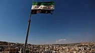 علم ثوري سوري يلوح فوق مبنى على مشارف حلب، سوريا، الثلاثاء 12 يونيو 2012. 