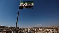 علم ثوري سوري يلوح فوق مبنى على مشارف حلب، سوريا، الثلاثاء 12 يونيو 2012. 