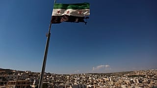 علم ثوري سوري يلوح فوق مبنى على مشارف حلب، سوريا، الثلاثاء 12 يونيو 2012. 