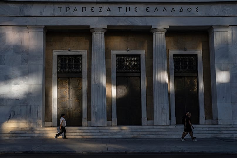 Des passants marchent devant le siège de la Banque de Grèce, dans le centre d'Athènes, mardi 8 octobre 2024