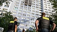 Police officers stand in front of a high-rise building after a fire in Friedrichshain, 14 August, 2026