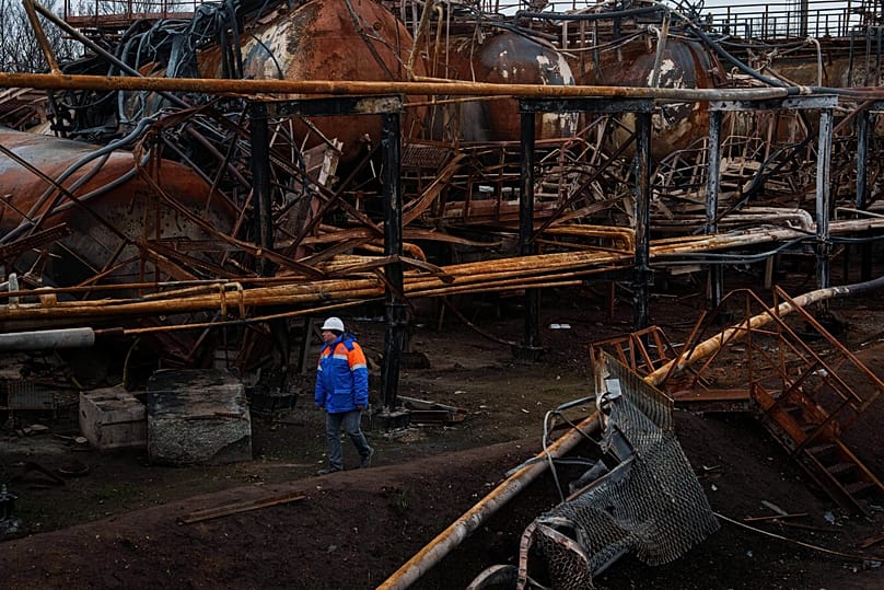 A Naftogaz worker walks in front of a gas extraction facility destroyed by a Russian strike in Ukraine, 18 November, 2025