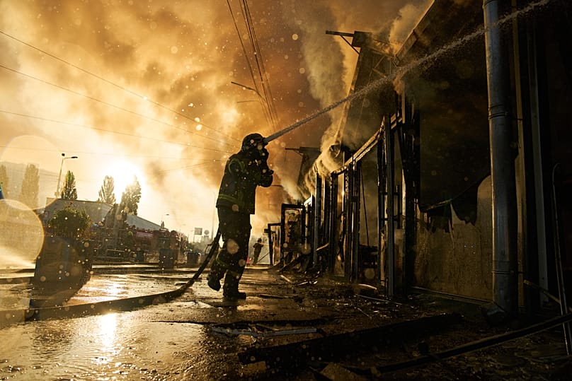 Firefighters try to put out a fire at a city book market following a Russian missile attack in Kyiv, 16 August, 2026