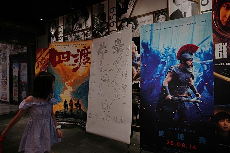 Un cartel dibujado que promociona Niu Lai expuesto junto a otros carteles de películas en un cine de Pekín, martes 18 de agosto de 2026