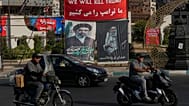 صورة من طهران (10 أغسطس 2026) لمركبات تمر أمام لافتات تتوعد بقتل ترامب، وأخرى للمرشد الراحل علي خامنئي وخليفته نجله مجتبى.