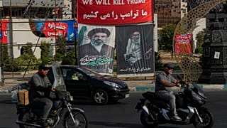 صورة من طهران (10 أغسطس 2026) لمركبات تمر أمام لافتات تتوعد بقتل ترامب، وأخرى للمرشد الراحل علي خامنئي وخليفته نجله مجتبى.