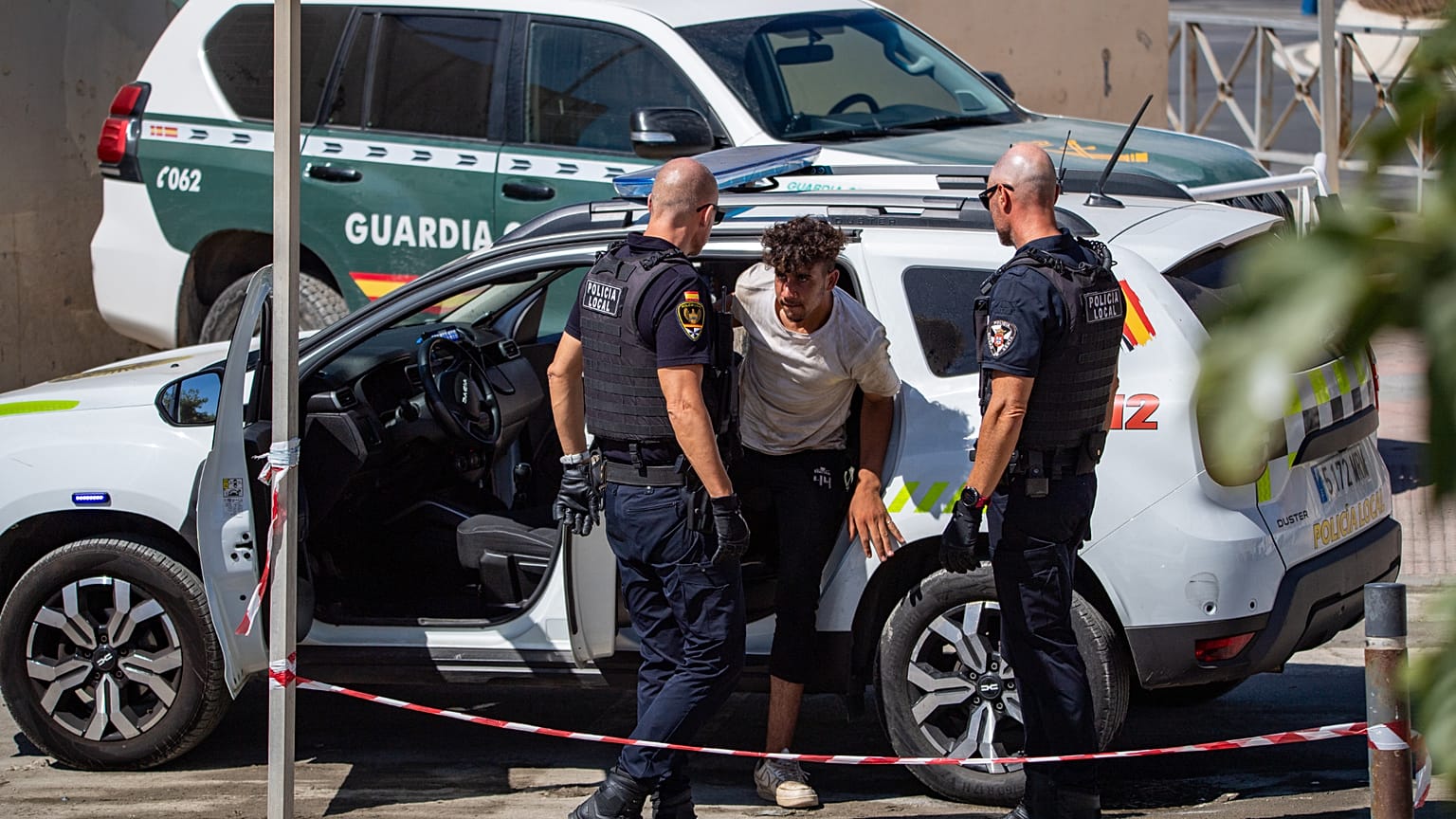 Un migrante que cruzó a España es escoltado por la Policía hacia la frontera hispano-marroquí para su regreso a Marruecos desde el enclave español de Ceuta