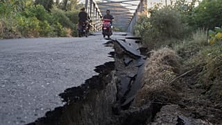 سائقو السيارات يركبون دراجاتهم النارية بالقرب من طريق تضرر بسبب الزلزال في شمال لامبا ليدا، مقاطعة نوسا تينجارا الشرقية، إندونيسيا، الثلاثاء 18 أغسطس 2026. 