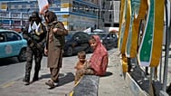 امرأة وطفل يراقبان مرور مسلحي طالبان بكابول، خلال احتفالات الذكرى الخامسة للانسحاب الأمريكي وعودة الحركة للسلطة في 15 أغسطس 2026.