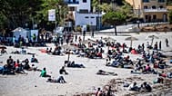 Los migrantes que cruzaron a España desde Marruecos se reúnen en una playa del enclave español de Ceuta, el domingo 2 de agosto de 2026. 