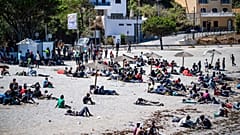 Los migrantes que cruzaron a España desde Marruecos se reúnen en una playa del enclave español de Ceuta, el domingo 2 de agosto de 2026. 