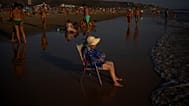 Una mujer se sienta en una silla mientras el sol se pone en la playa de Zahara de los Atunes en Cádiz, España, el jueves 13 de agosto de 2026