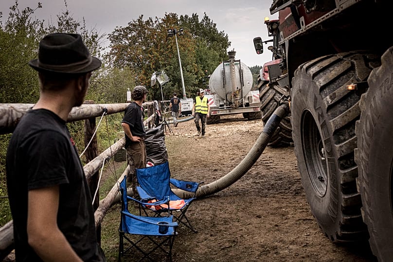 Farmers fill their tractor trailers with water at a local lake as they work to extinguish a wildfire burning near Sourbrodt, 17 August, 2026