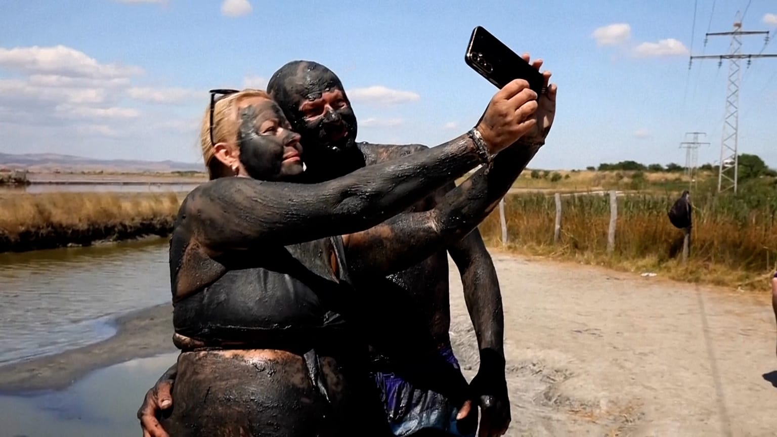 Ζευγάρι καλυμμένο με λάσπη ποζάρει για μια selfie στη λίμνη Ατανασόβσκο, στο Μπουργκάς της Βουλγαρίας, στις 14 Αυγούστου 2026.