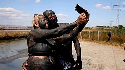 Ein mit Schlamm bedecktes Paar macht am 14. August 2026 am Atanasovsko-See bei Burgas in Bulgarien ein Selfie.