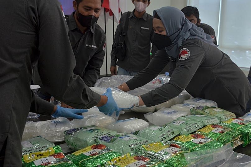 Police officers arrange bags of methamphetamine confiscated from suspected smugglers in Palu, 28 December, 2021