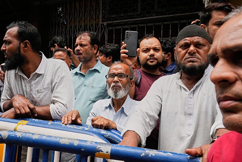 Onlookers watch after a fire at a building in Kolkata, India, on 19 August 2026.