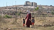 رقية، زوجة المالك الفلسطيني الأمريكي المقيم في ولاية أوهايو لوي ريدي، تمشي مع ابنتيهما كيندا، 2، على اليسار، وحور، 4، في منزلهما الذي حاصره المستوطنون الإسرائيليون 