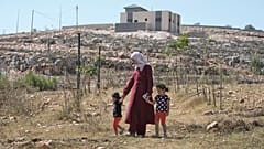 رقية، زوجة المالك الفلسطيني الأمريكي المقيم في ولاية أوهايو لوي ريدي، تمشي مع ابنتيهما كيندا، 2، على اليسار، وحور، 4، في منزلهما الذي حاصره المستوطنون الإسرائيليون 