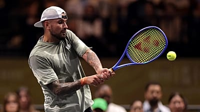 Nick Kyrgios, 28 Aralık 2025'te Dubai'deki Cinsiyetler Savaşı maçında Aryna Sabalenka'ya karşı backhand vuruşu yapıyor.