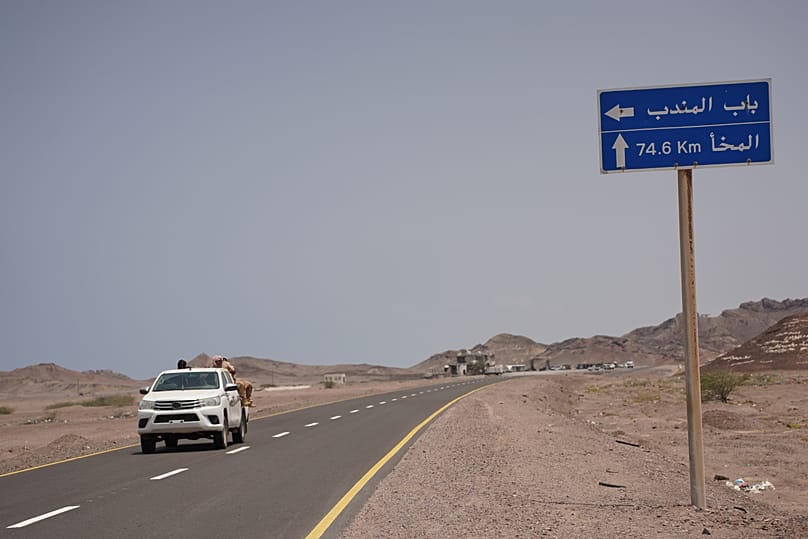 مركبة تمر قرب لافتة تشير إلى مدخل مضيق باب المندب على الطريق الساحلي بين عدن والحديدة في اليمن، 5 نيسان 2026.
