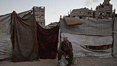 رجل فلسطيني يجلس بجوار خيمته، حيث يحتمي وسط أنقاض المباني التي دمرتها الغارات الجوية الإسرائيلية خلال الحرب مع حماس، في مدينة غزة، الاثنين 17 أغسطس/آب 2026.