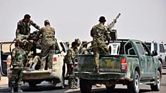 FILE: Syrian troops and pro-government gunmen standing on pickup trucks mounted with heavy machine guns, in the eastern city of Deir el-Zour, 4 September 2017