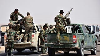 أرشيف: الجنود السوريون ومسلحون موالون للحكومة يقفون على شاحنات بيك أب مزودة برشاشات ثقيلة، في مدينة دير الزور شرقي البلاد، في الرابع من سبتمبر 2017