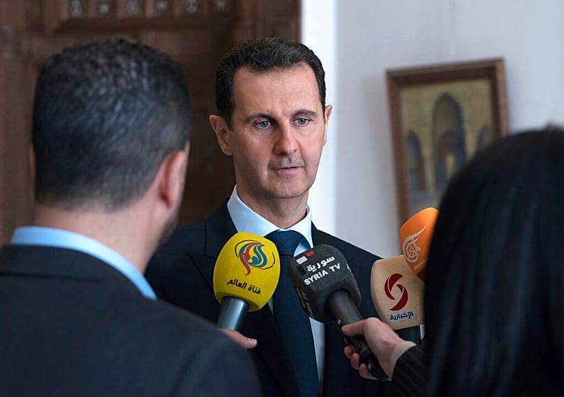 FILE - Ex-Syrian President Bashar al-Assad speaks with reporters, after issuing a decree granting amnesty and reducing sentences for several categories of crime, March 4, 2018