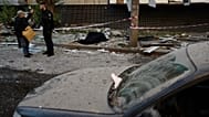 A policeman talks to a local resident next to the bodies of two people killed during an overnight Russian attack in Kyiv, Ukraine, Thursday, Aug. 20, 2026. (AP Photo/Francisco