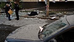 Policjant rozmawia z mieszkańcem obok ciał dwóch osób zabitych w nocnym rosyjskim ataku na Kijów, Ukraina, czwartek, 20 sierpnia 2026 r. (AP Photo/Francisco