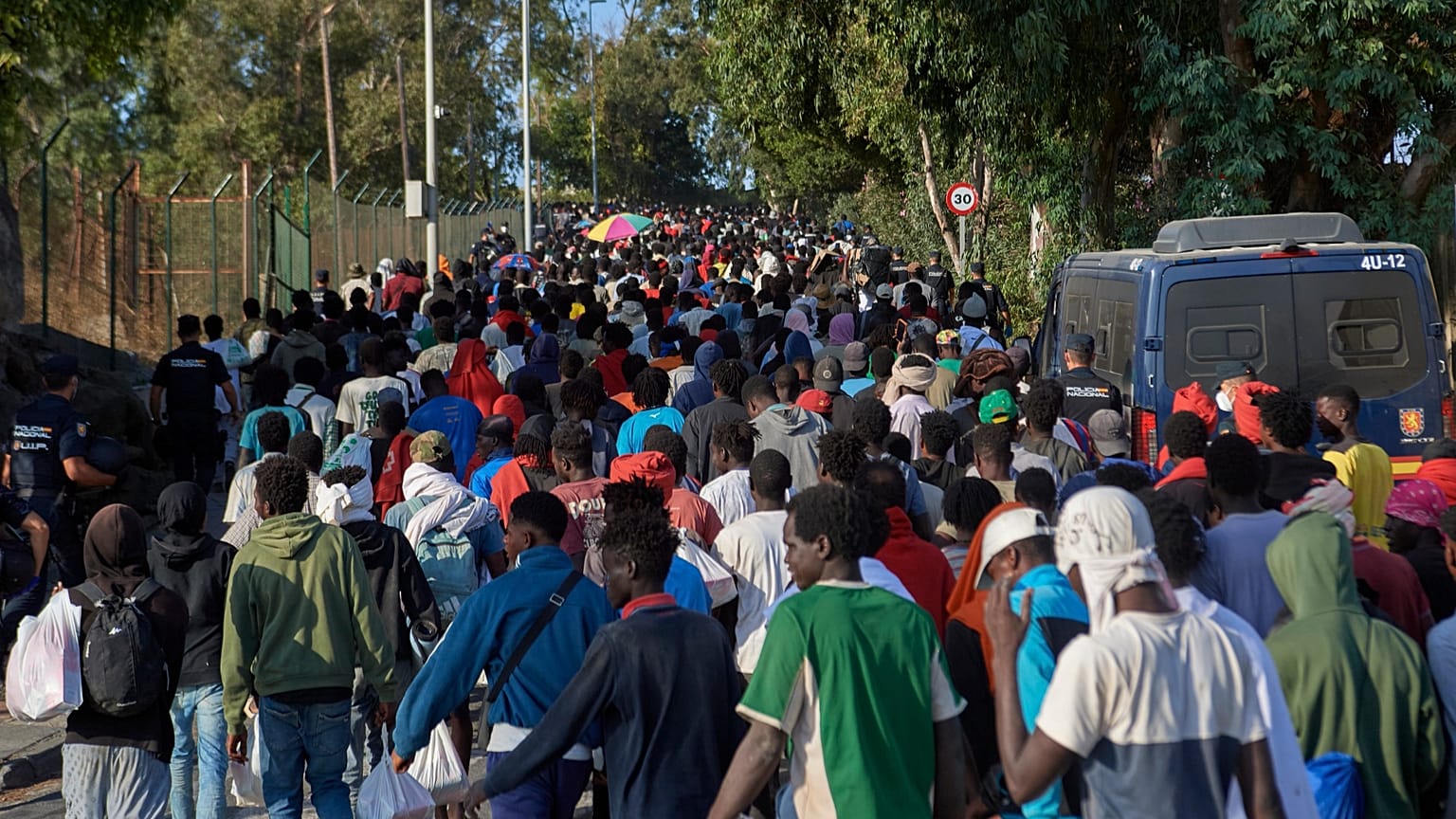 Migrants who crossed from Morocco into Spain are escorted by Spanish police to temporary shelters after being cleared from a beach in Ceuta, 20 August, 2026