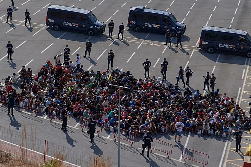 Migrants who crossed from Morocco into Spain are escorted by Spanish police to temporary shelters after being cleared from a beach in Ceuta, 20 August, 2026
