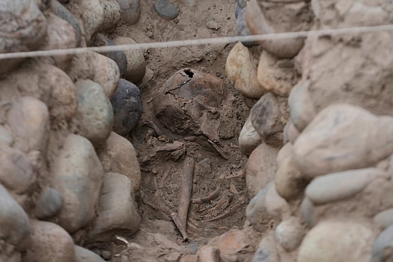 Skeletal remains are exposed while being excavated by archeologists at the Huaca Pucllana archaeological site in Lima, Peru, Tuesday, Aug. 18, 2026. 