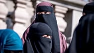 Women wearing niqabs stand outside the Danish Parliament in Copenhagen on 31 May 2018, as Denmark approved a ban on garments covering the face.
