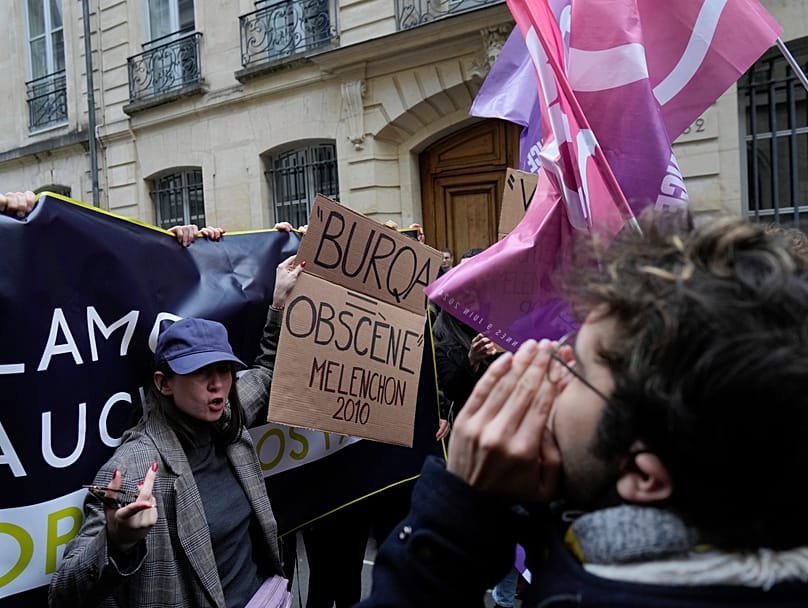 Nemesis founder Alice Cordier protests against a conference by Jean-Luc Mélenchon at Sciences Po in Paris on 22 April 2024, holding a sign reading "Burqa=obscene".