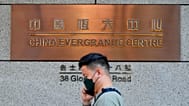 A man walks past the entrance of the headquarters of China Evergrande Group in Hong Kong Monday, Oct. 4, 2021. 