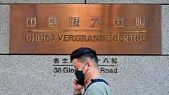 Mężczyzna przechodzi obok wejścia do siedziby China Evergrande Group w Hongkongu, poniedziałek 4 października 2021 r.