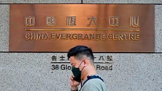 A man walks past the entrance of the headquarters of China Evergrande Group in Hong Kong Monday, Oct. 4, 2021. 