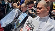 Exiled Tibetans get their heads shaved as a mark of protest against China's new ethnic unity law in New Delhi
