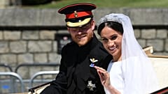 Książę Harry i Meghan machają do tłumu z karety po swoim ślubie na zamku Windsor 19 maja 2018 r. (Paul Ellis/Pool Photo via AP)