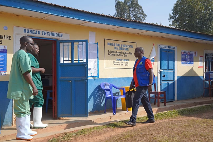 Gédéon Banga Ngbape, right, an Ebola surveillance officer, arrives at his office in Nizi, Ituri province, eastern Congo, Friday, 14 Aug., 2026. 