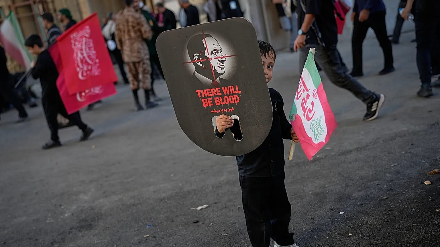 طفل يحمل صورة رئيس الوزراء الإسرائيلي بنيامين نتنياهو، مع عبارة "ستُراق الدماء"، خلال مراسم تشييع علي خامنئي في طهران، 5 تموز 2026.