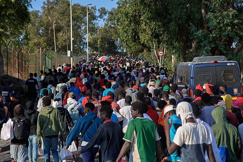 Migrants who crossed from Morocco into Spain are escorted by Spanish police to temporary shelters after being cleared from a beach in Ceuta, 20 August, 2026