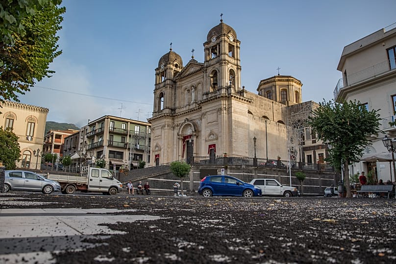 La ceniza volcánica cubre la plaza de la iglesia de Santa Maria della Provvidenza, en Zafferana Etnea, Sicilia, lunes, 9 de agosto de 2021. 