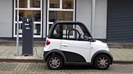 Un coche eléctrico compacto en blanco y negro en un punto de carga