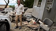 American actor Liev Schreiber stands next to destroyed cars during his trip for Ukraine's Independence day as UNITED24 ambassador in Kyiv, Ukraine, Thursday, Aug. 20, 2026. 