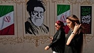 صورة تعبيرية- تسير نساء بجوار صورة للمرشد الأعلى الإيراني الراحل علي خامنئي