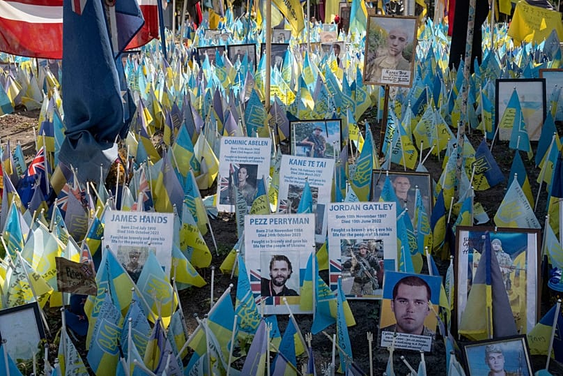 Bandeiras com nomes de voluntários internacionais mortos são transportadas durante o Dia da Independência da Ucrânia, em Kiev, 24 de agosto de 2024