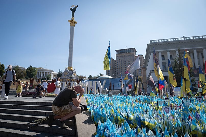 Um veterano presta homenagem num memorial improvisado aos soldados ucranianos mortos, em Kiev, 24 de agosto de 2024